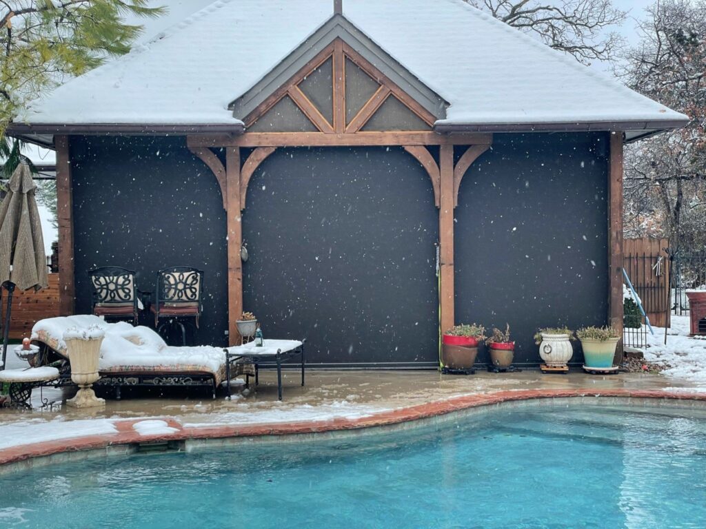 A poolside remote all-season outdoor room in winter, fully screened-in and protected from the elements.