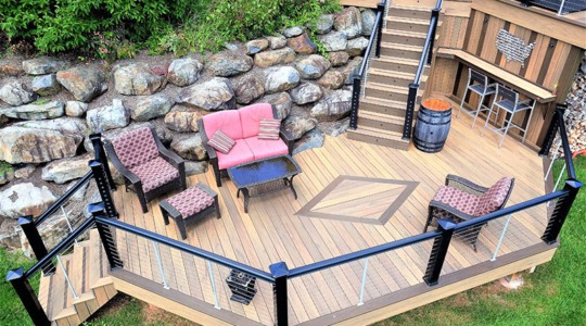 An impressive, custom-designed, multi-tiered wooden deck with various seating areas and safety railings.
