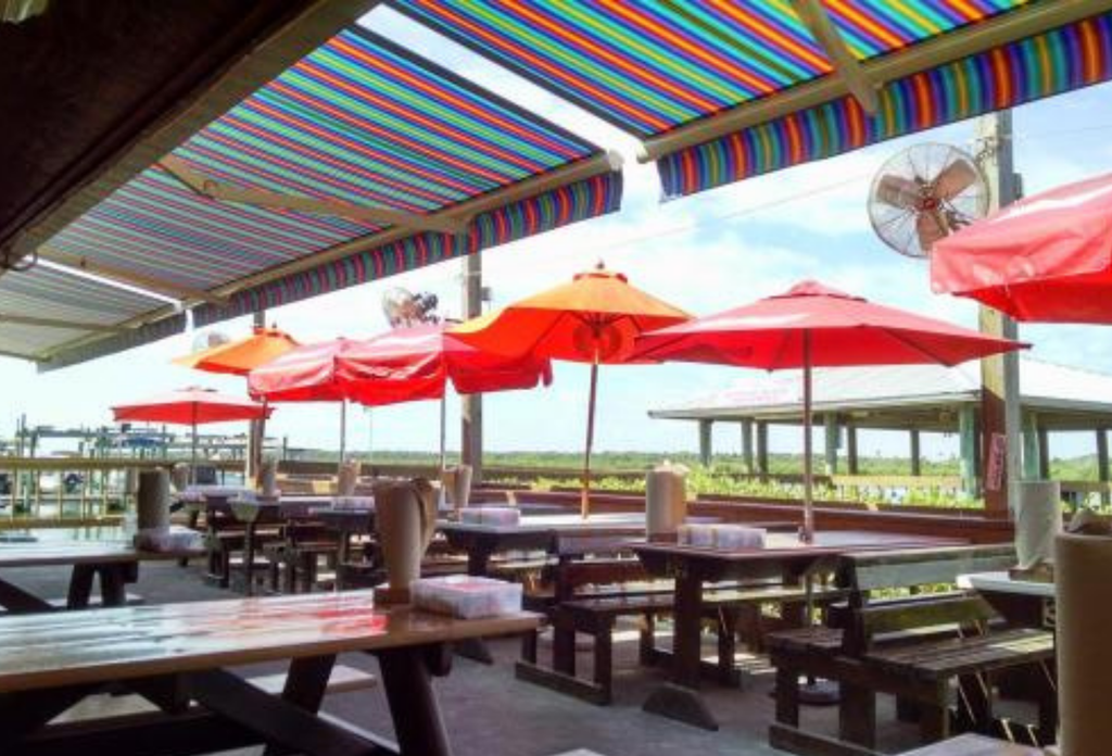 A colorful row of extended retractable awnings installed for a commercial patio.