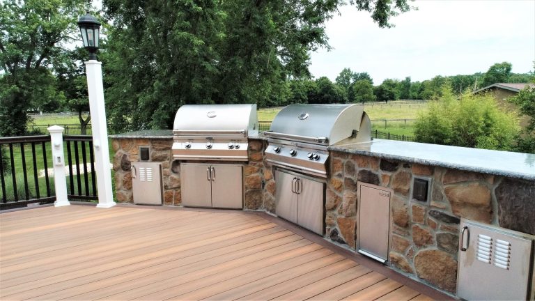 Composite deck with a built-in stone outdoor kitchen and grill