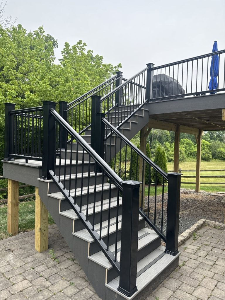 Deck stairs with a landing and black railing