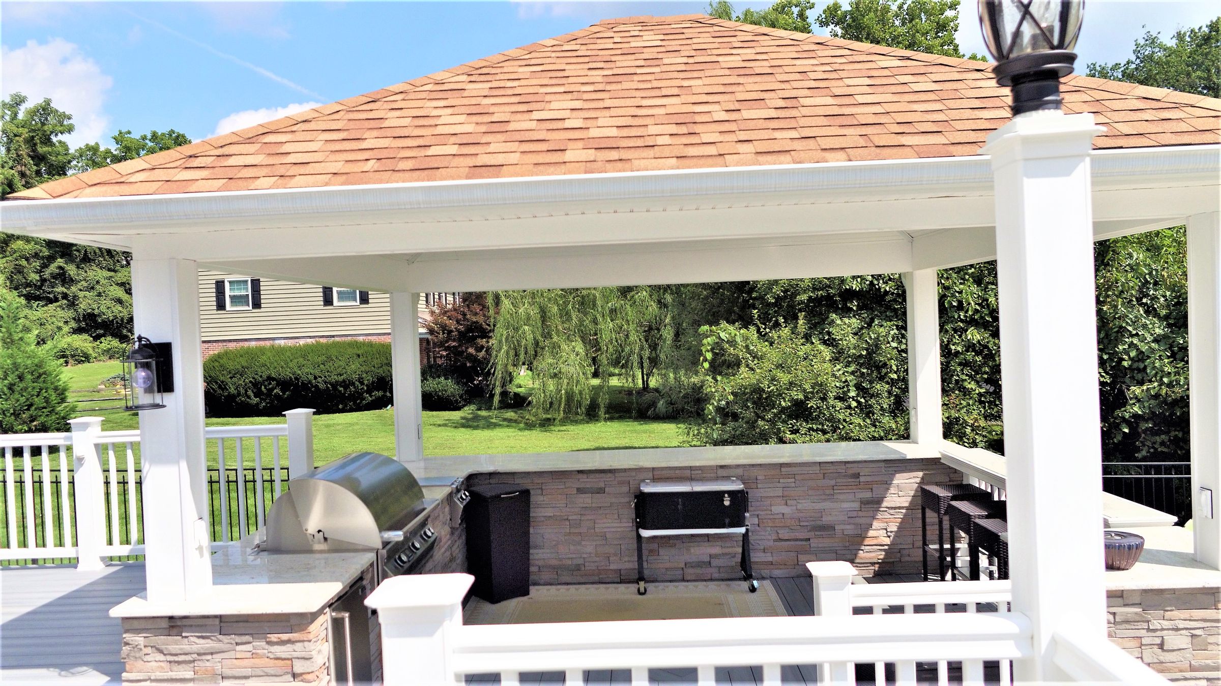 Gazebo covering an outdoor kitchen and seating area