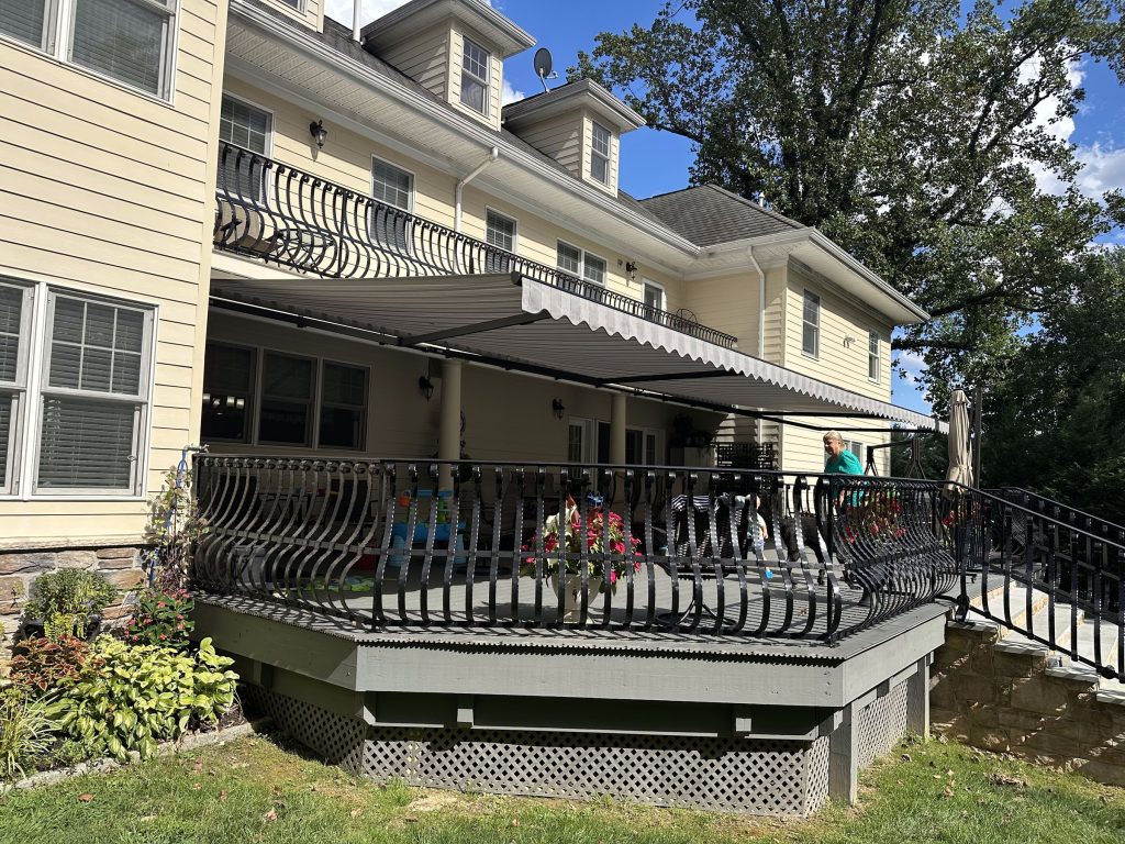 Retractable awning extended over an elevated deck