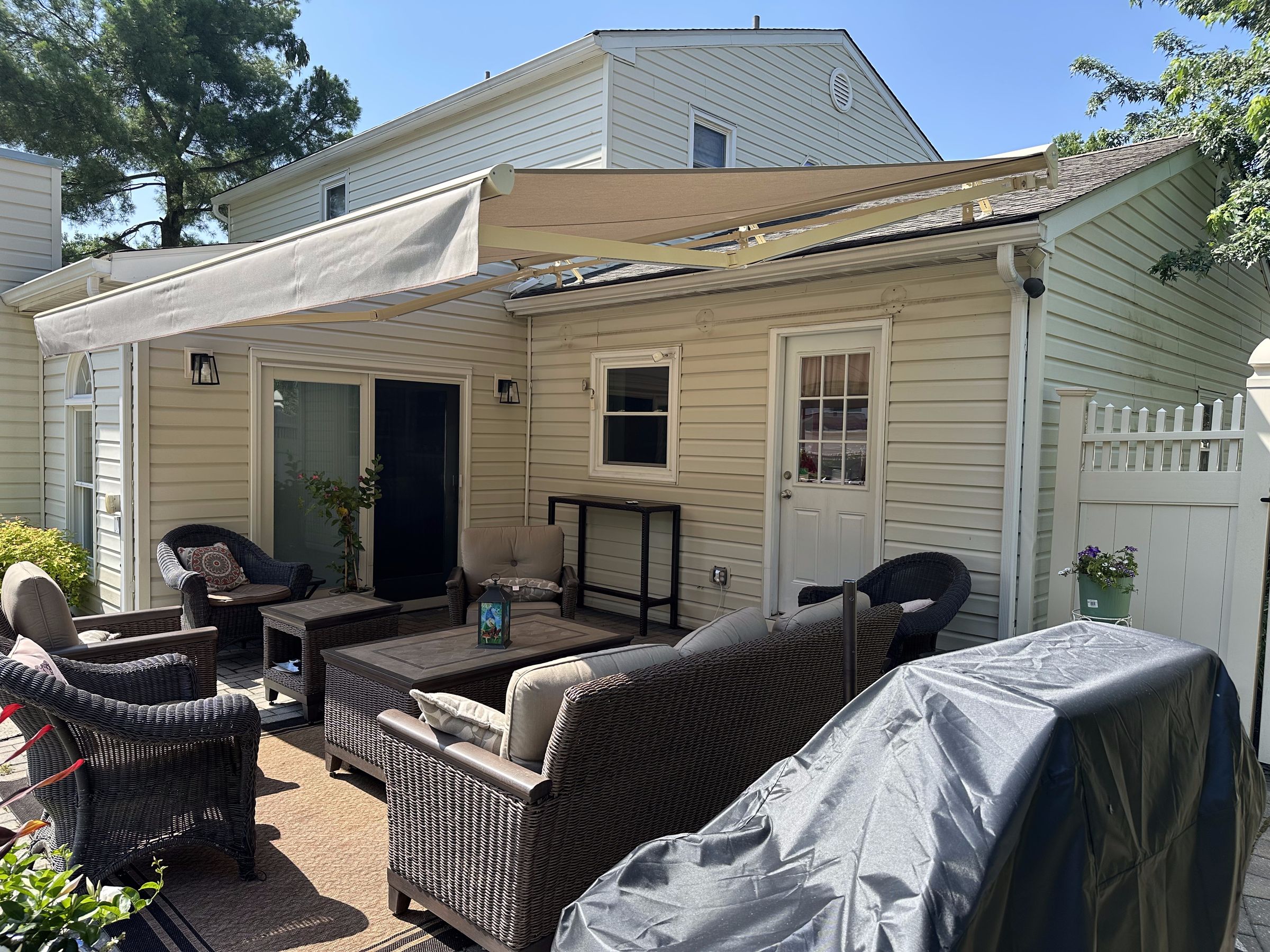 Retractable awning over a paver patio seating area